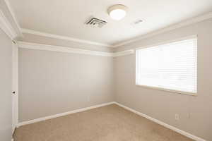 Empty room with light colored carpet and ornamental molding