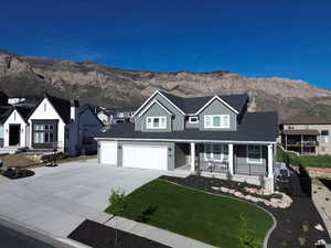 Contemporary two-story residence featuring a gray siding exterior, white trim accents, and a covered front porch