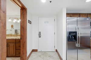Doorway featuring tile patterned floors and baseboards