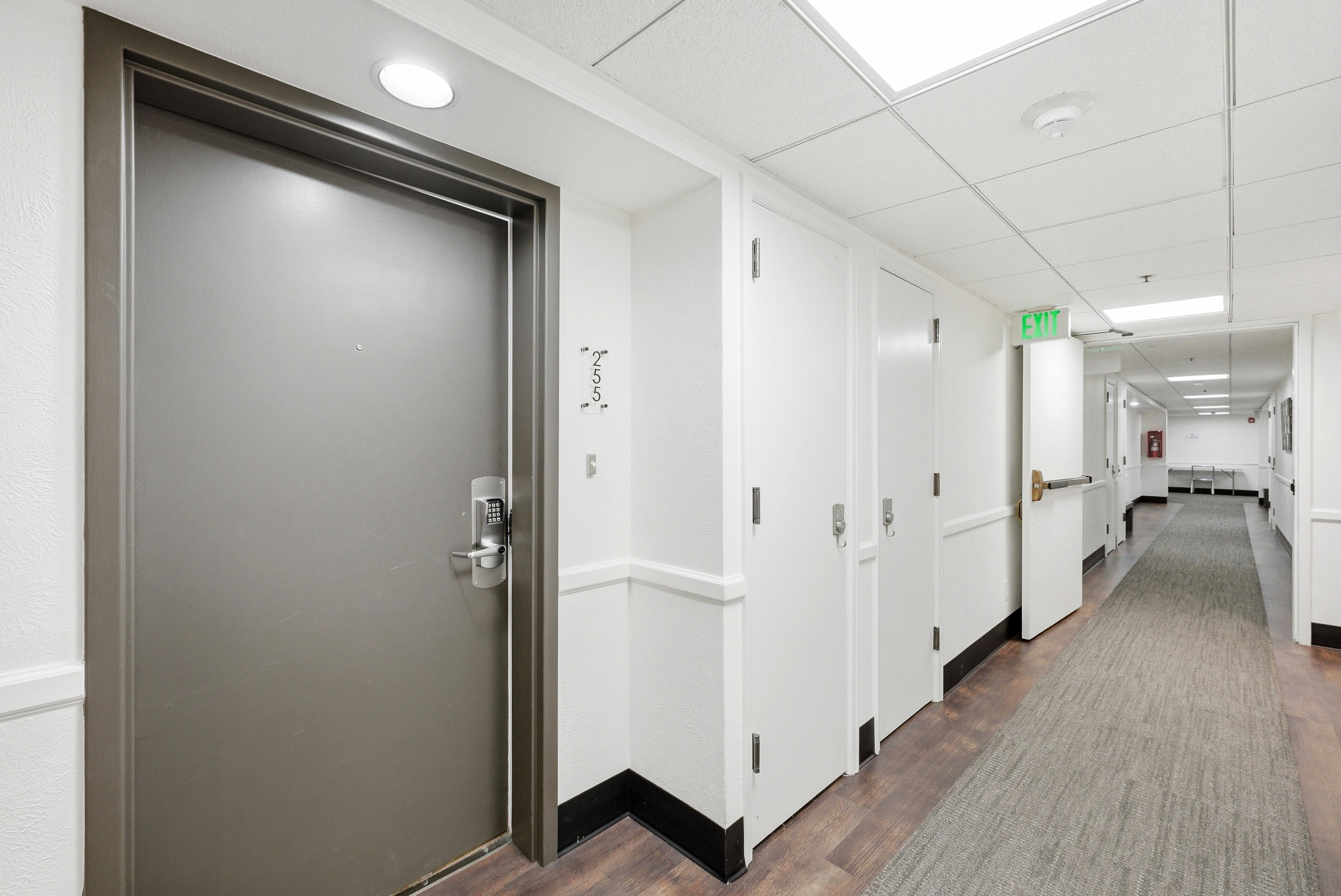 Corridor featuring a drop ceiling and dark wood-style flooring