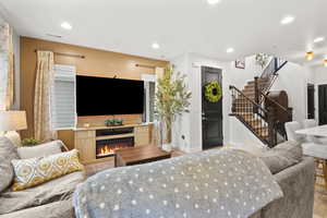 Living area featuring a lit fireplace and recessed lighting