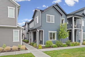 View of front of house with a balcony and a front yard