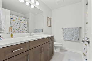 Full bathroom with vanity, a shower with shower curtain, and light tile patterned floors