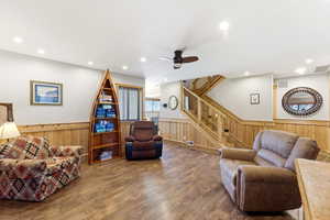 Living room with wainscoting, ceiling fan, hardwood / wood-style floors, wooden walls, and recessed lighting