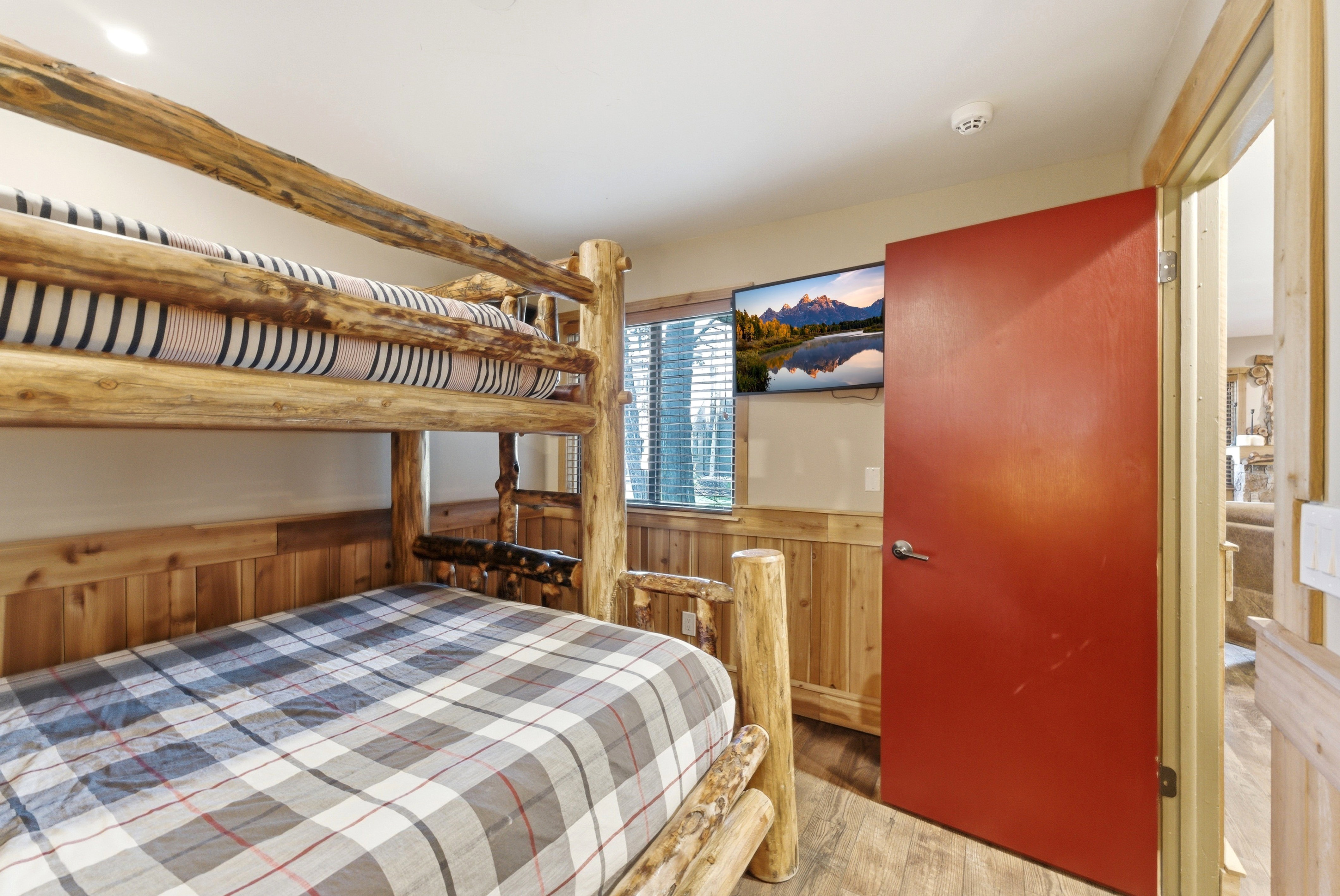 Bedroom featuring a wainscoted wall, wooden walls, and light wood-type flooring