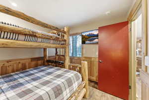 Bedroom featuring a wainscoted wall, wooden walls, and light wood-type flooring