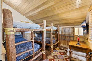 Bedroom with a vaulted wood ceiling and wood finished floors