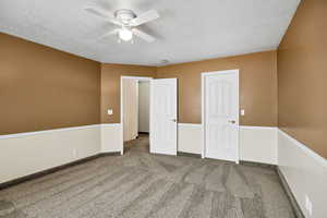 Unfurnished bedroom with carpet, a textured ceiling, and ceiling fan