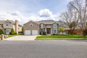 View of front of home featuring brick siding, driveway, and an attached garage