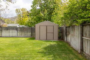 View of shed with a fenced backyard and a mountain view