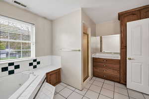 Full bath featuring a shower stall, vanity, light tile patterned floors, and a jetted tub
