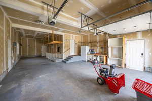 Garage featuring freestanding refrigerator and a garage door opener
