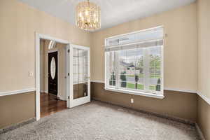 Entryway with carpet floors and hanging lights