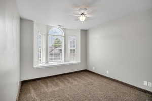 Unfurnished room featuring ceiling fan and carpet flooring