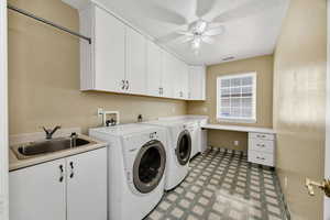 Laundry area with ceiling fan, light flooring, washing machine and dryer, cabinet space, and an office area