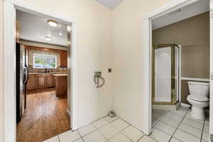 Bathroom featuring a shower stall, backsplash, light tile patterned floors, and a textured ceiling