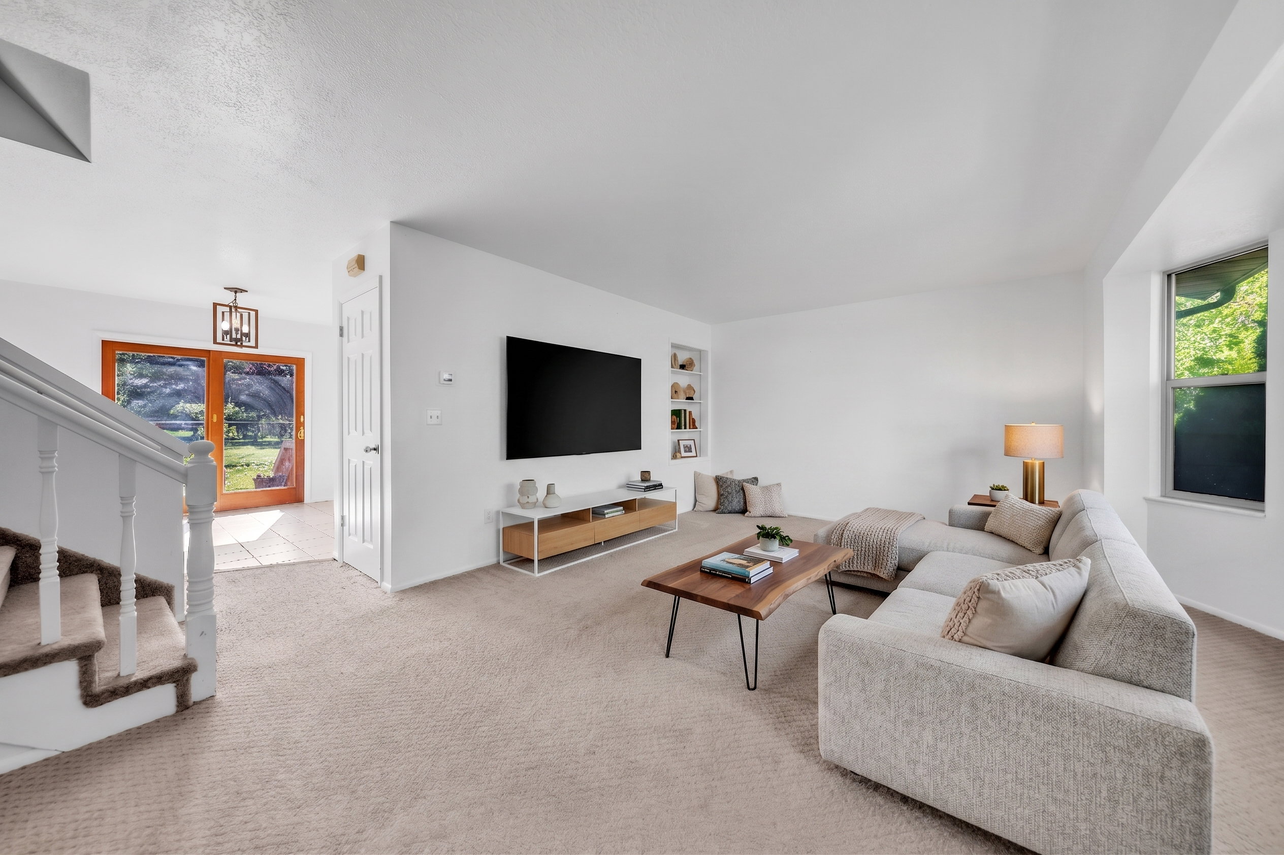 Living area featuring light carpet and built in shelves