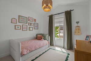 Bedroom featuring lofted ceiling and light colored carpet