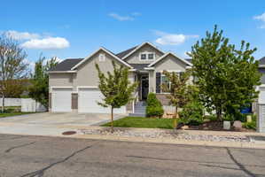 View of front of home featuring a garage, driveway, stucco siding, and brick siding