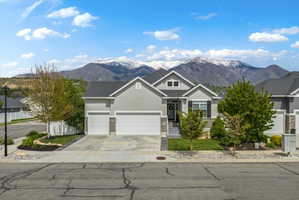 View of front of house with a garage, a mountain view, stucco siding, and concrete driveway