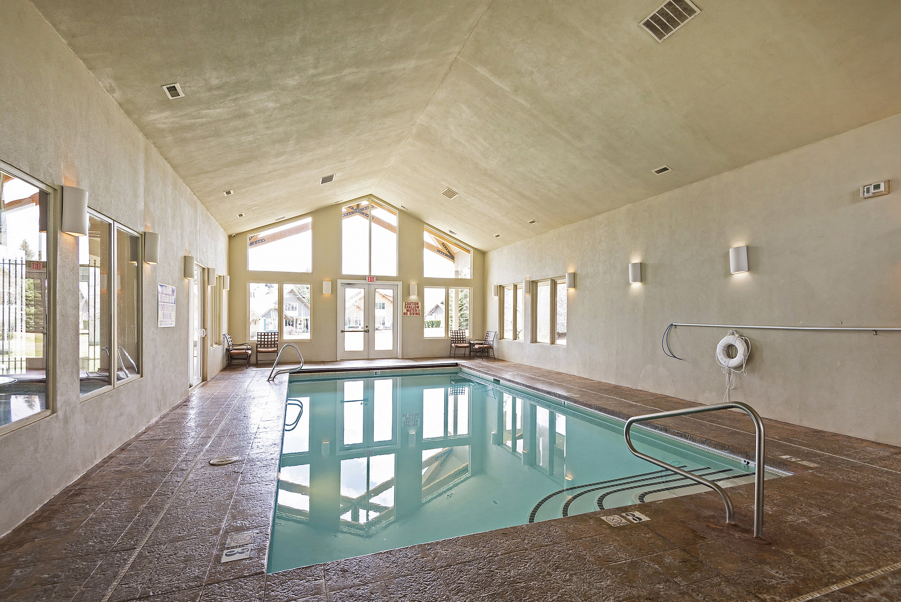 Indoor pool featuring a sunroom, french doors, and a ceiling fan