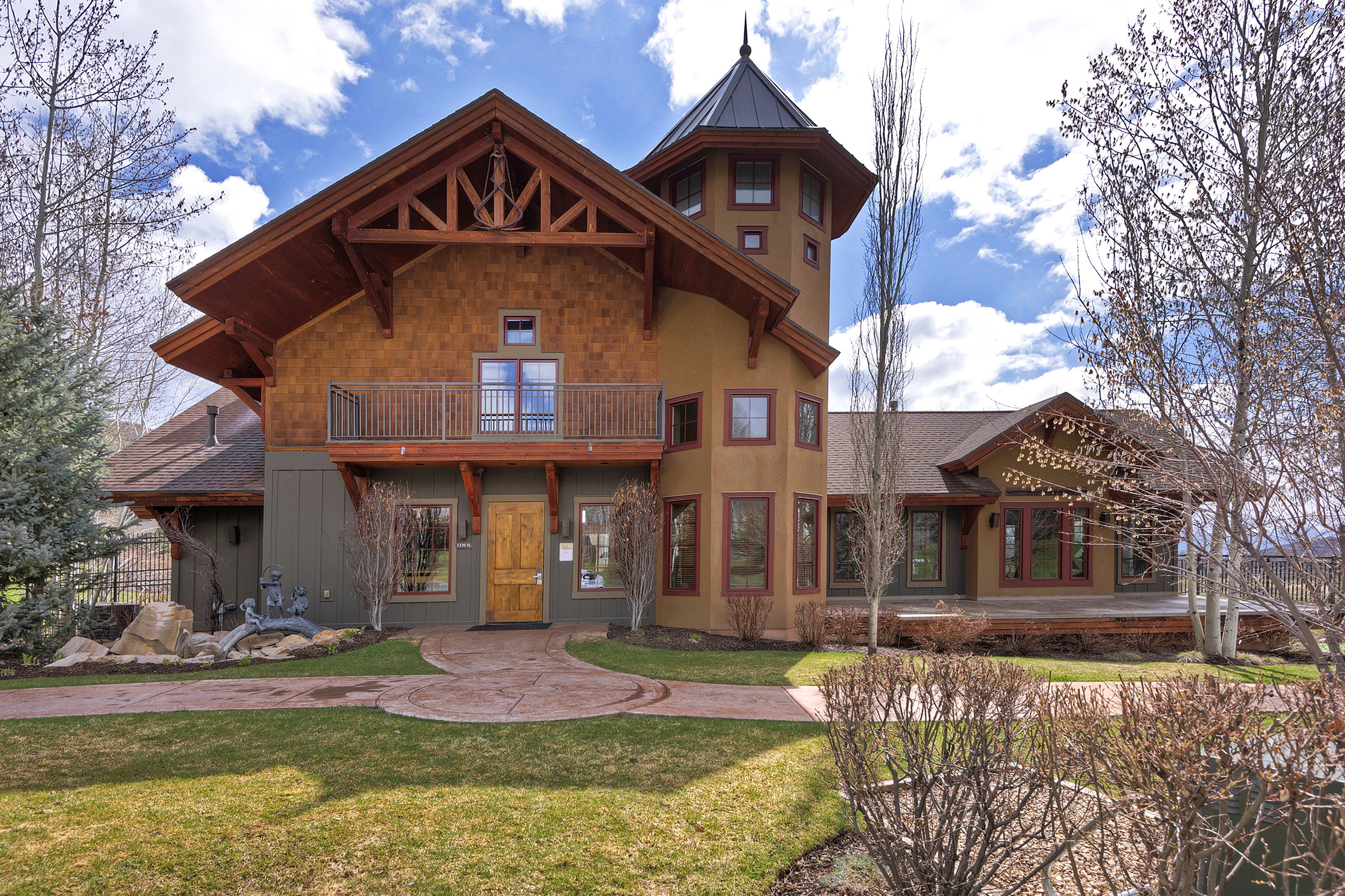 View of front of home with a balcony and a front yard