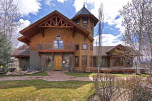 View of front of home with a balcony and a front yard