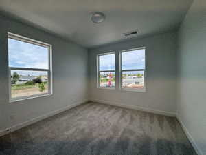 Spare room featuring light carpet and a textured ceiling