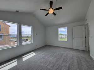 Carpeted empty room with ceiling fan and baseboards