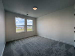 Empty room featuring carpet and baseboards