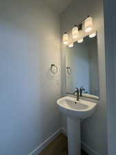 Bathroom featuring baseboards and dark wood finished floors