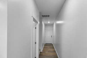 Corridor with baseboards and dark wood-style flooring