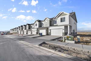 View of asphalt street featuring a residential view, curbs, and sidewalks