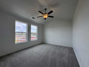 Empty room with carpet flooring, ceiling fan, and vaulted ceiling