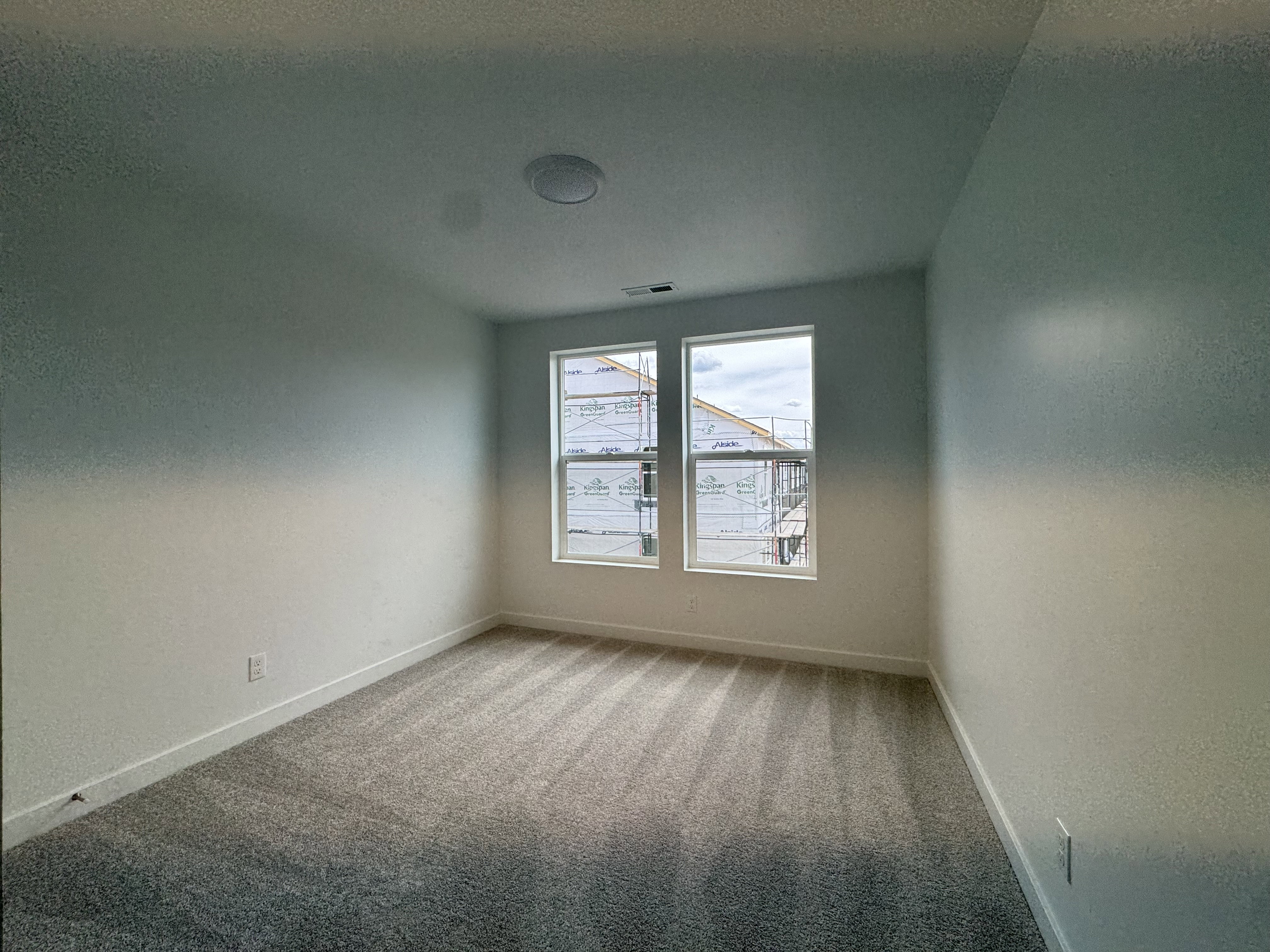 Empty room featuring light carpet and baseboards