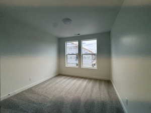 Empty room featuring light carpet and baseboards