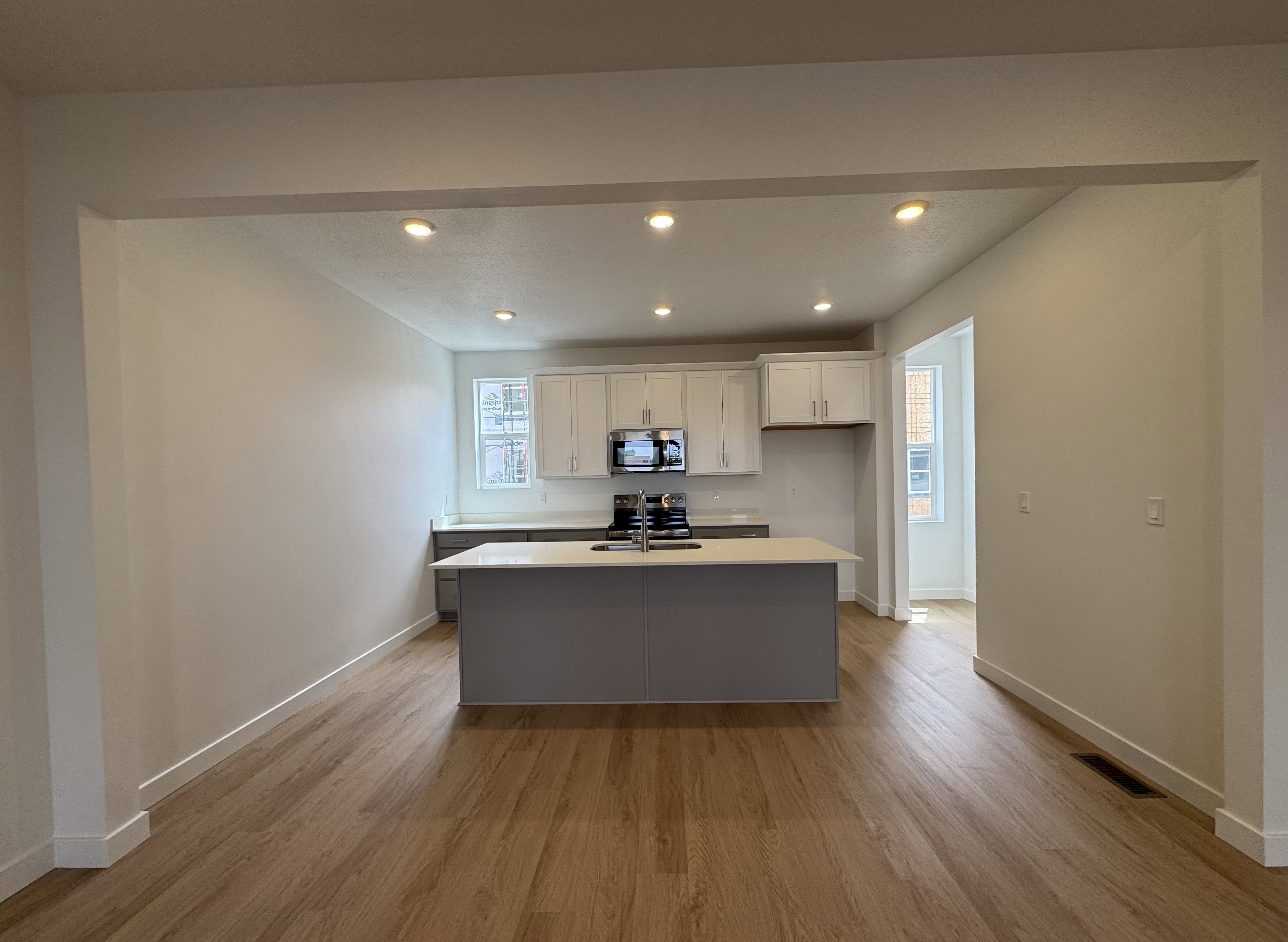 Kitchen featuring white cabinets, light wood-style flooring, recessed lighting, a kitchen island with sink, and stainless steel appliances