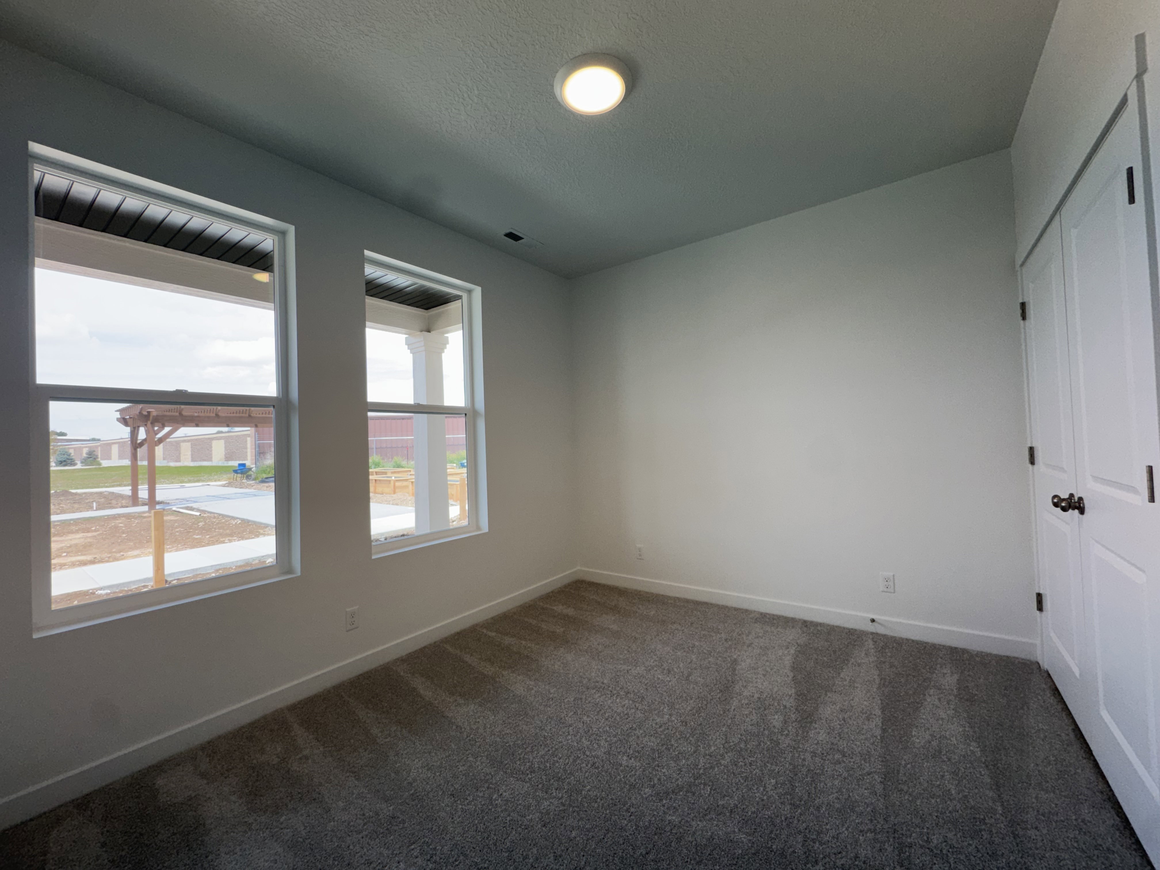 Unfurnished bedroom featuring a closet, dark carpet, and a textured ceiling