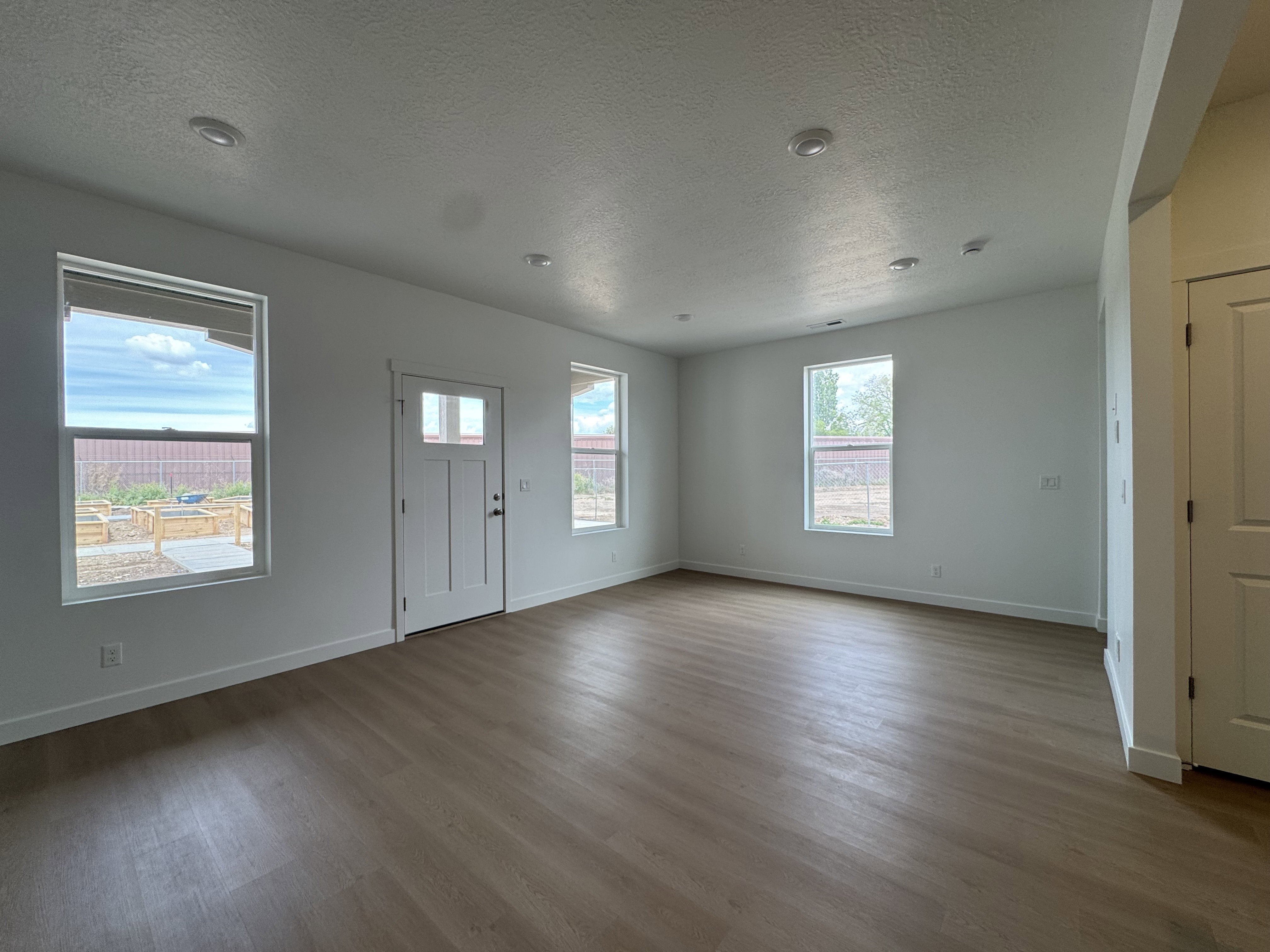 Entrance foyer with a textured ceiling and dark wood-style floors