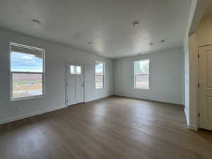Entrance foyer with a textured ceiling and dark wood-style floors