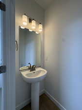 Bathroom featuring baseboards and dark wood finished floors