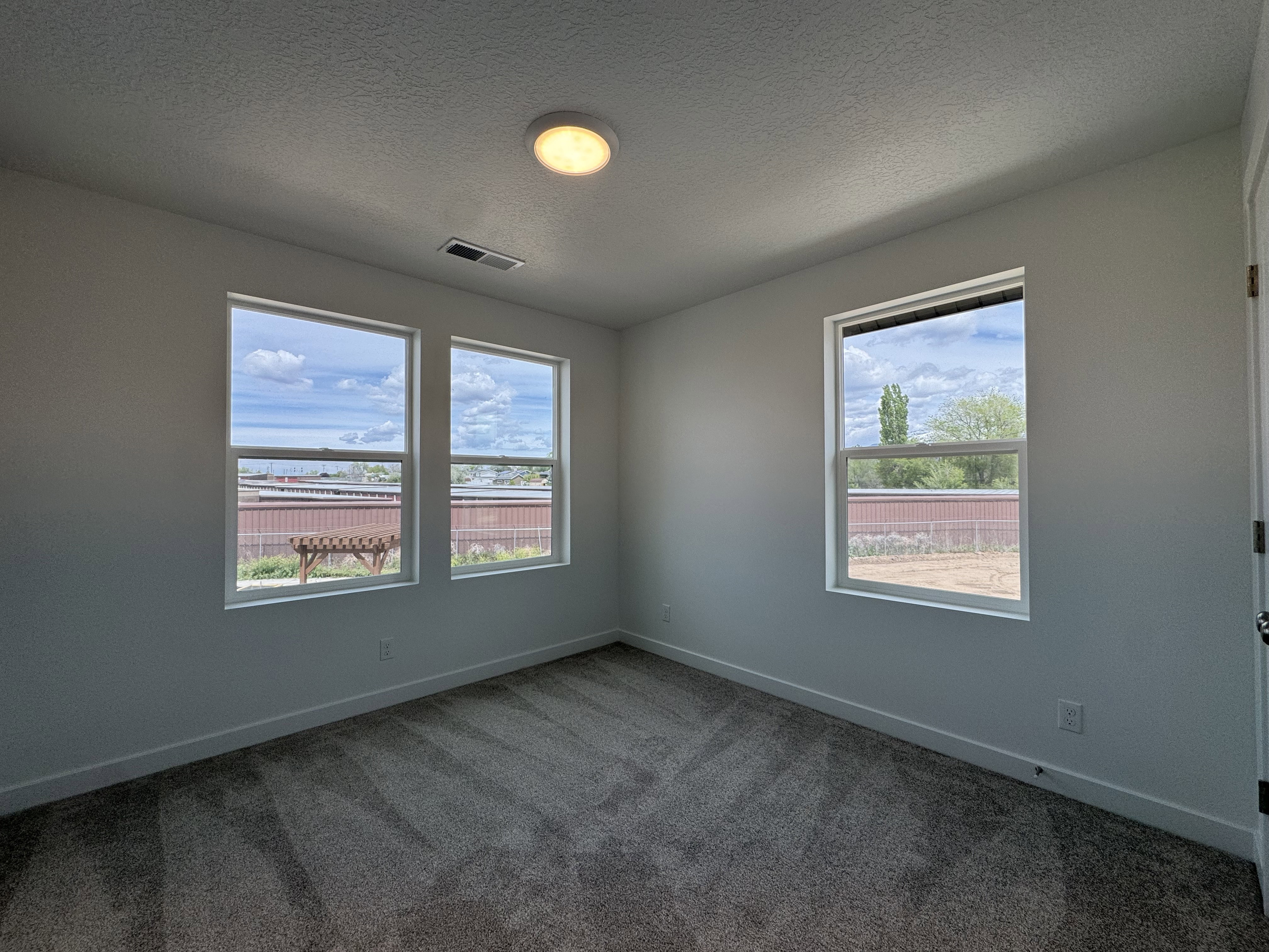 Unfurnished room featuring dark carpet and a textured ceiling