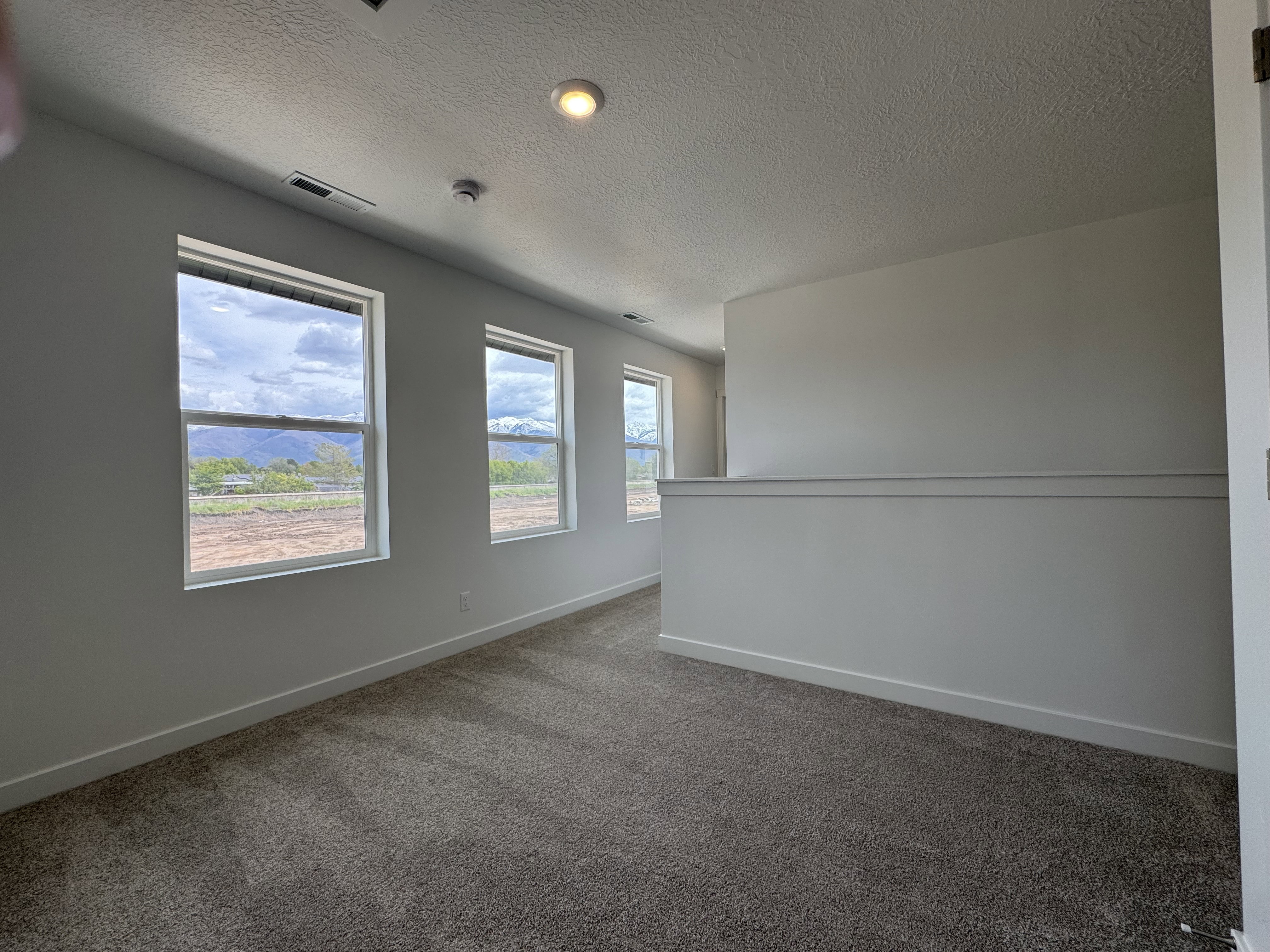 Unfurnished room with dark carpet and a textured ceiling