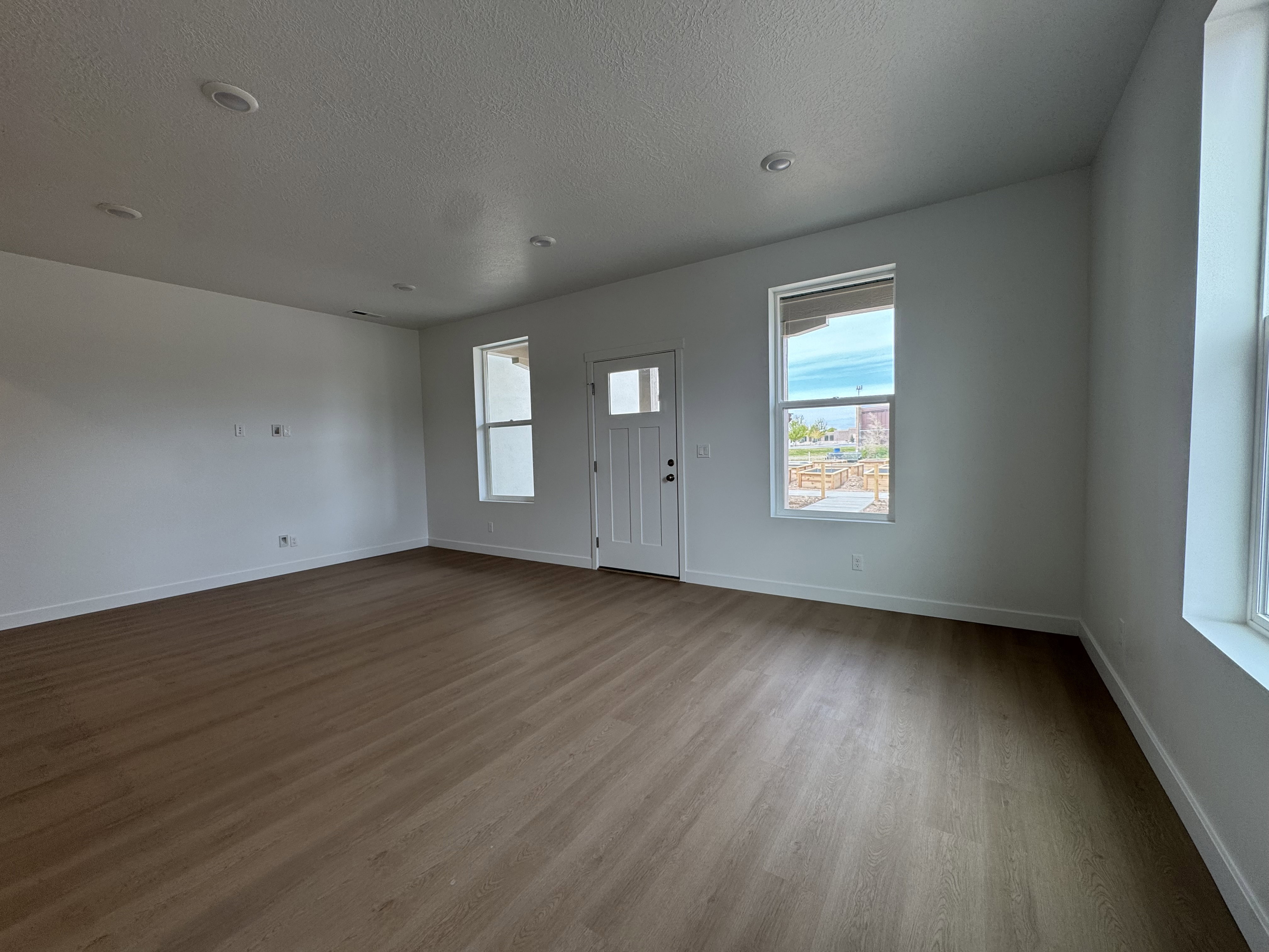 Foyer featuring dark wood finished floors, healthy amount of natural light, and a textured ceiling