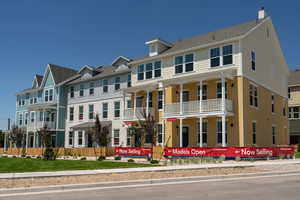 View of front facade with covered porch and stucco siding