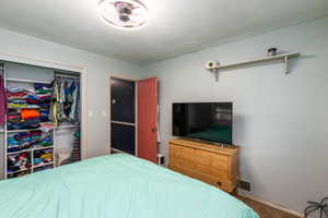 Bedroom with a closet, carpet floors, and a textured ceiling