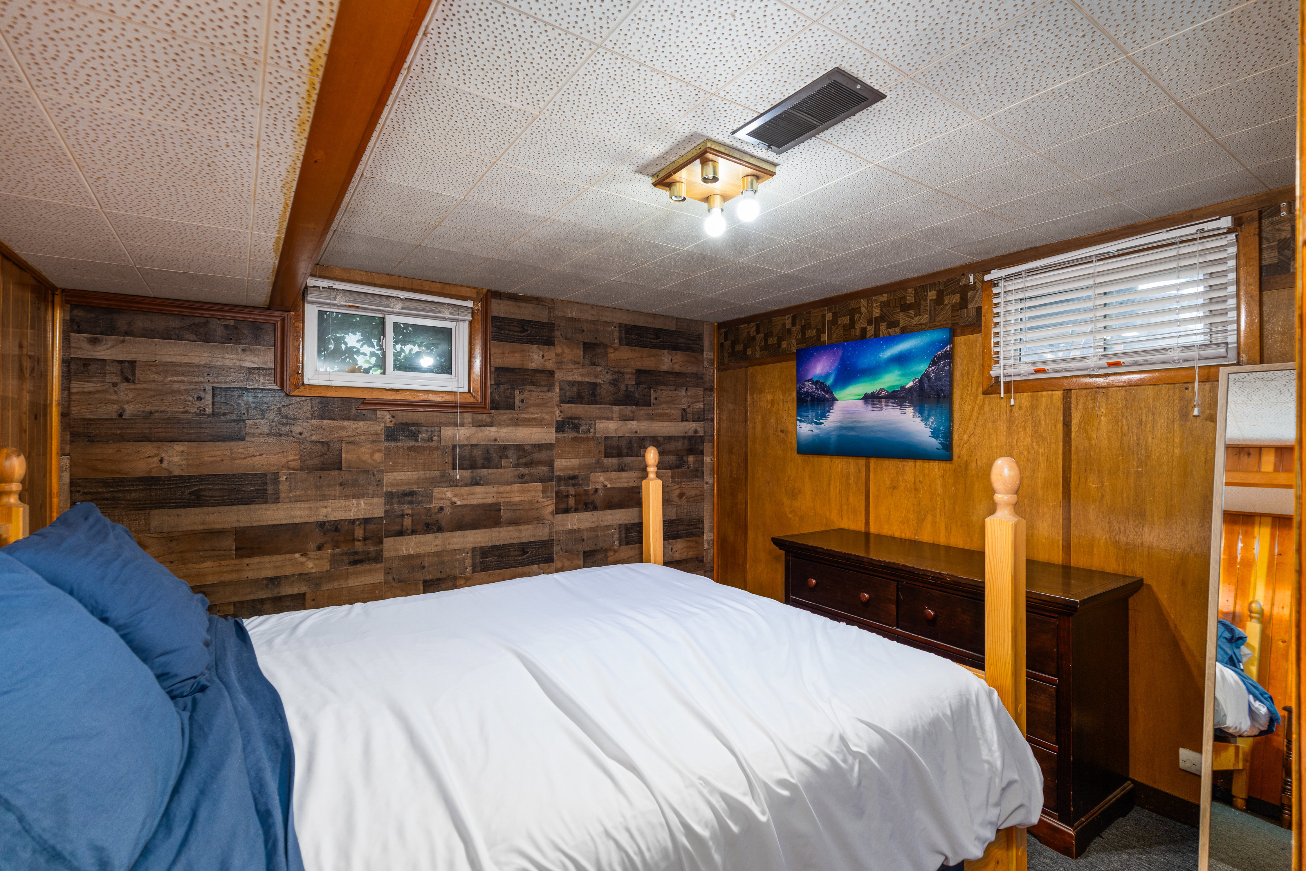 Bedroom with wood walls and dark colored carpet