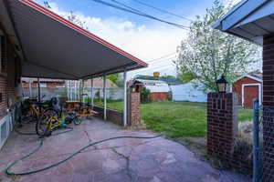 Fenced backyard with a storage shed and a patio area