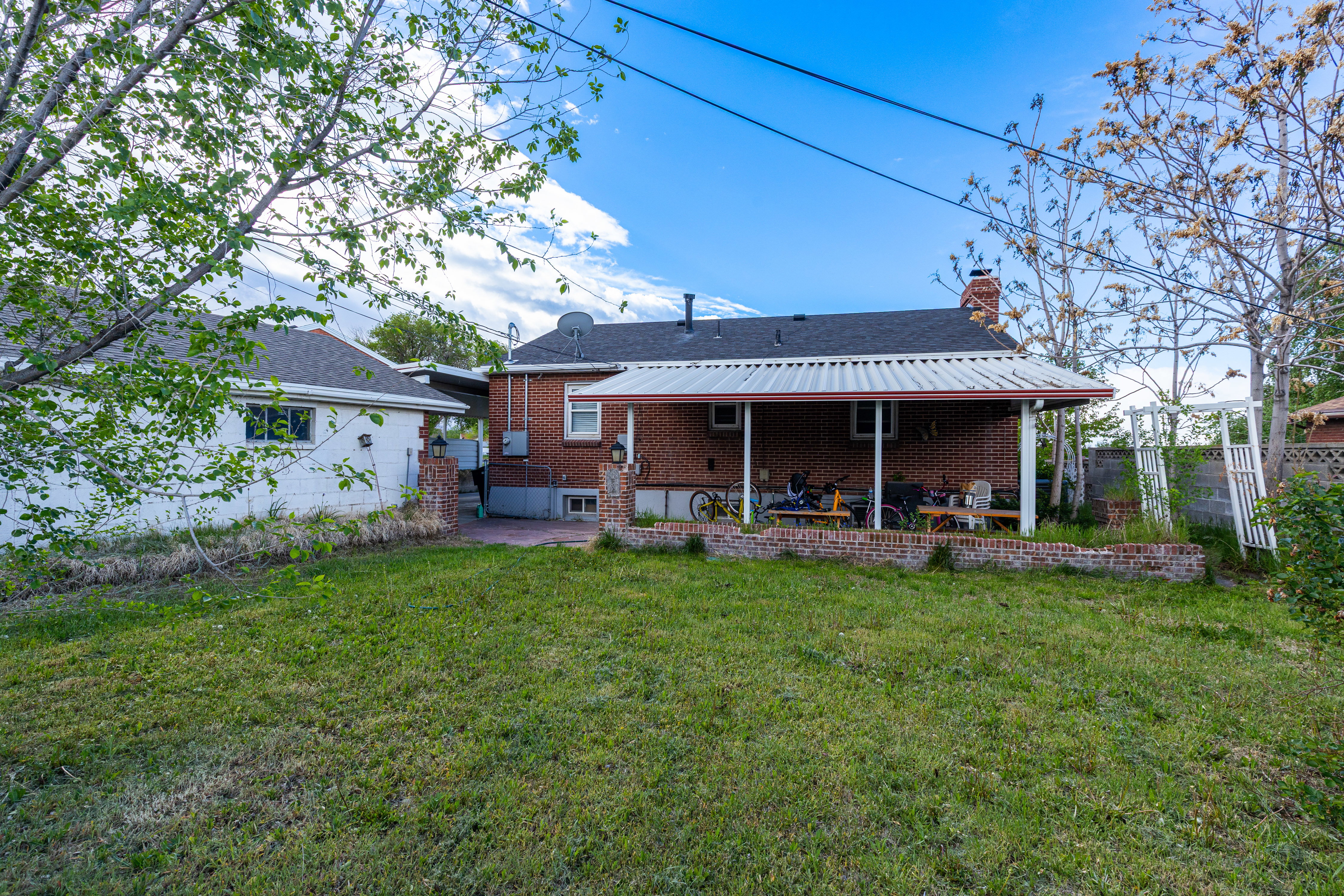 Back of property featuring a patio area, a chimney, and brick siding