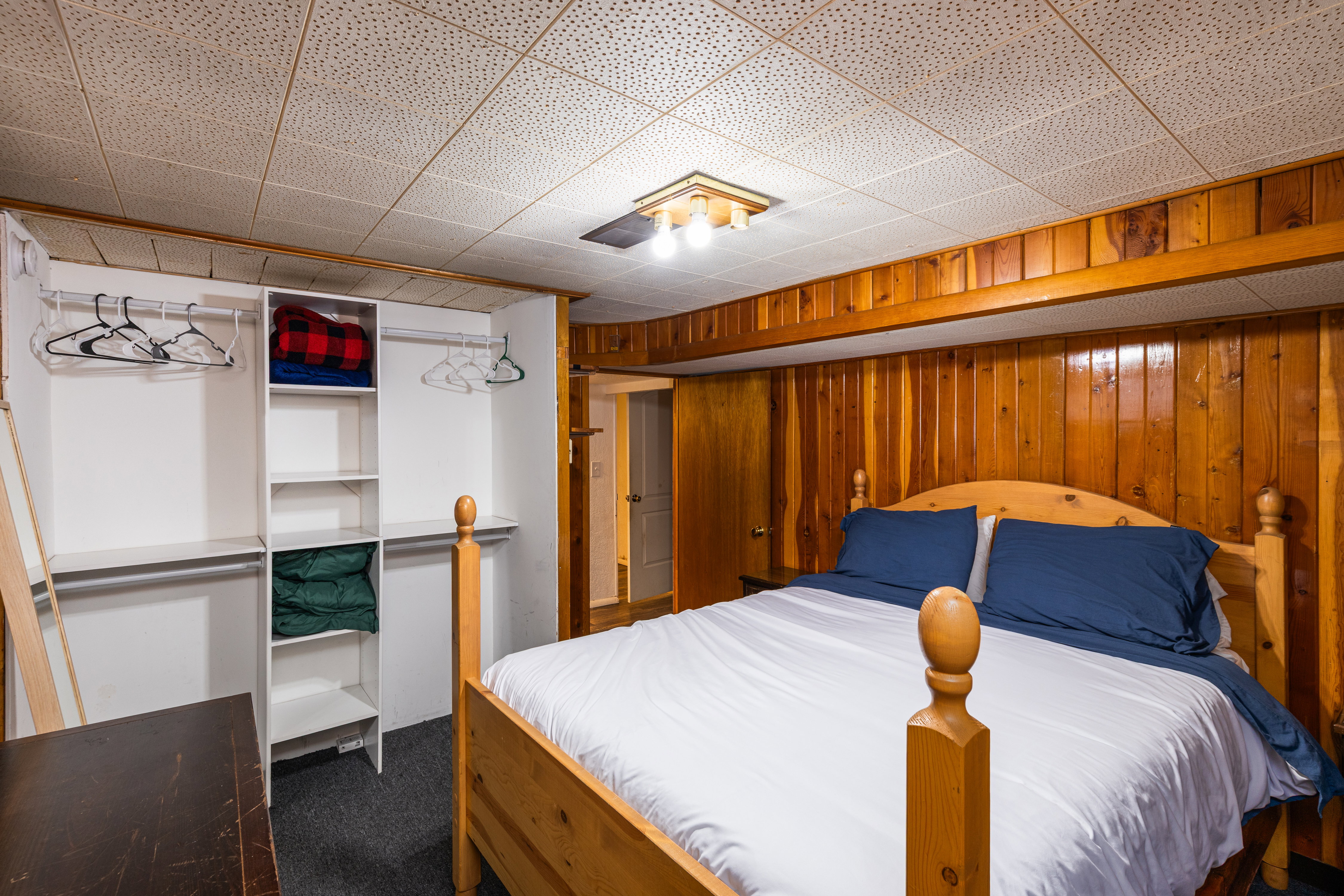 Bedroom featuring a closet, dark carpet, and wooden walls